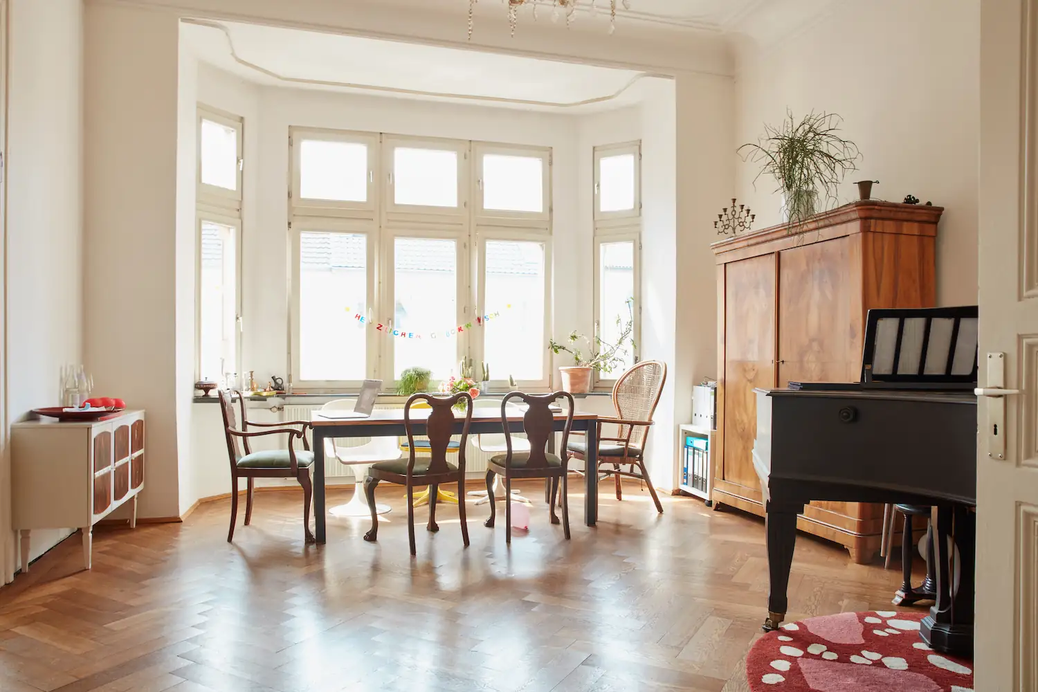 Lichtdurchflutetes Esszimmer mit Holztisch und großen Fenstern