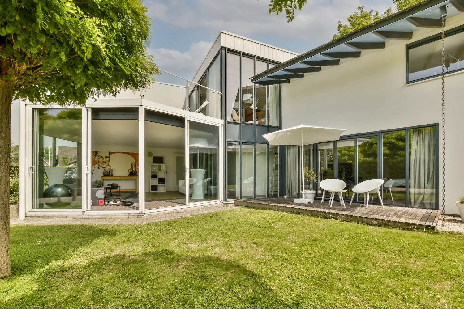 Modernes Wohnhaus mit Glasfassade, Terrasse und Rasenfläche