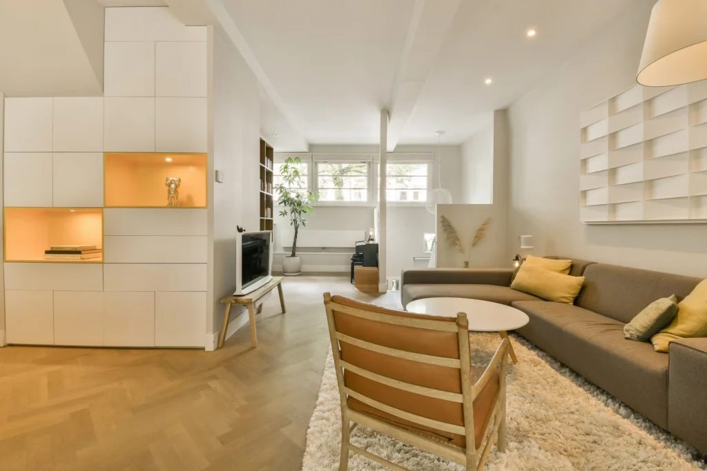 Wohnzimmer mit offener Küche, Holzboden und Sofa